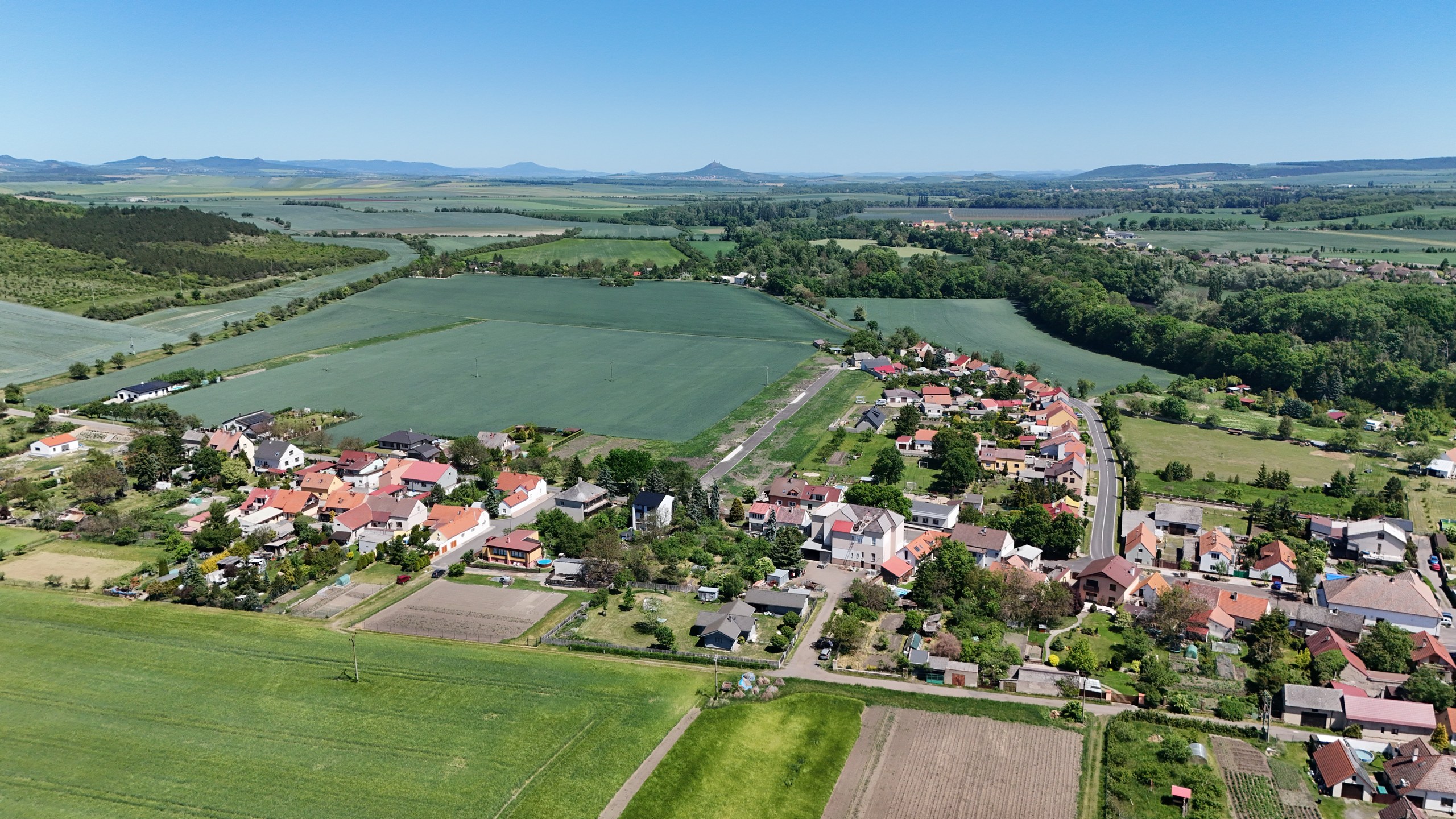 Pozemky u Tří dubů — obec, nová ulice a okolní krajina